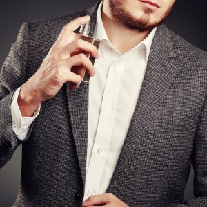 Handsome Young Man using Perfume. Young Man in Business Suit. Casual Style